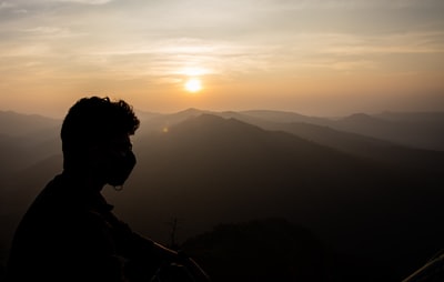 轮廓的人站在山在日落
